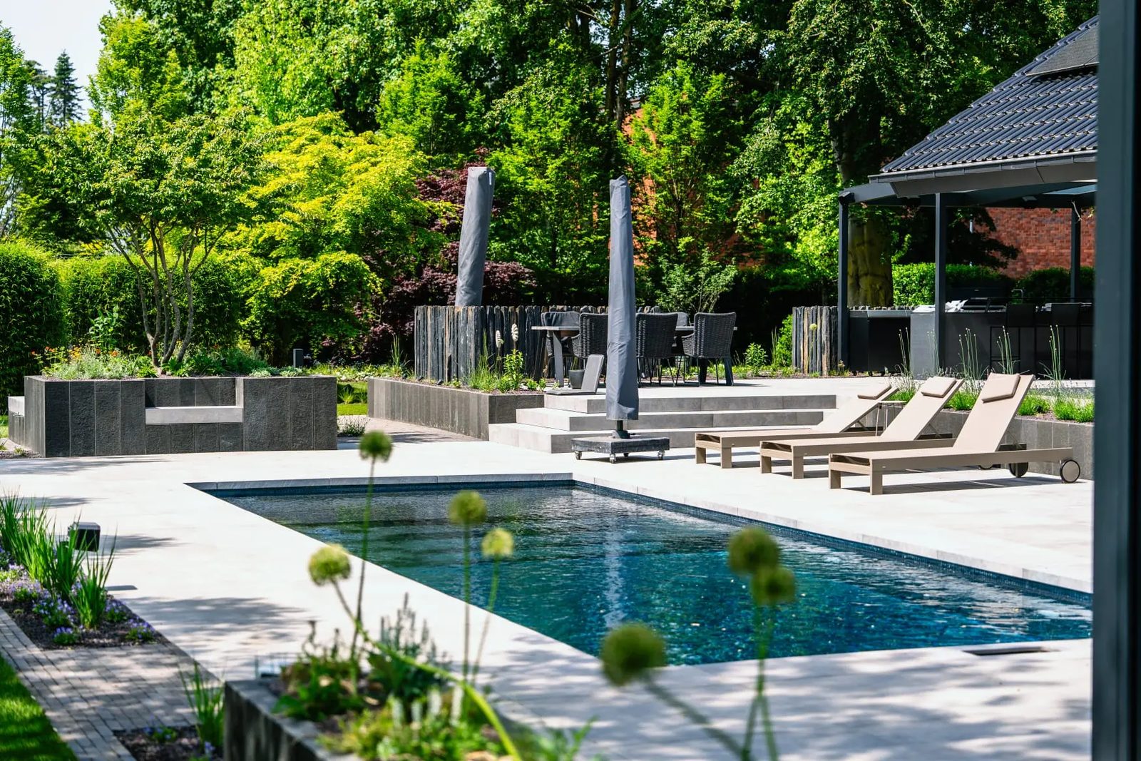 Moderner Garten mit Pool, Terrasse und üppiger Bepflanzung