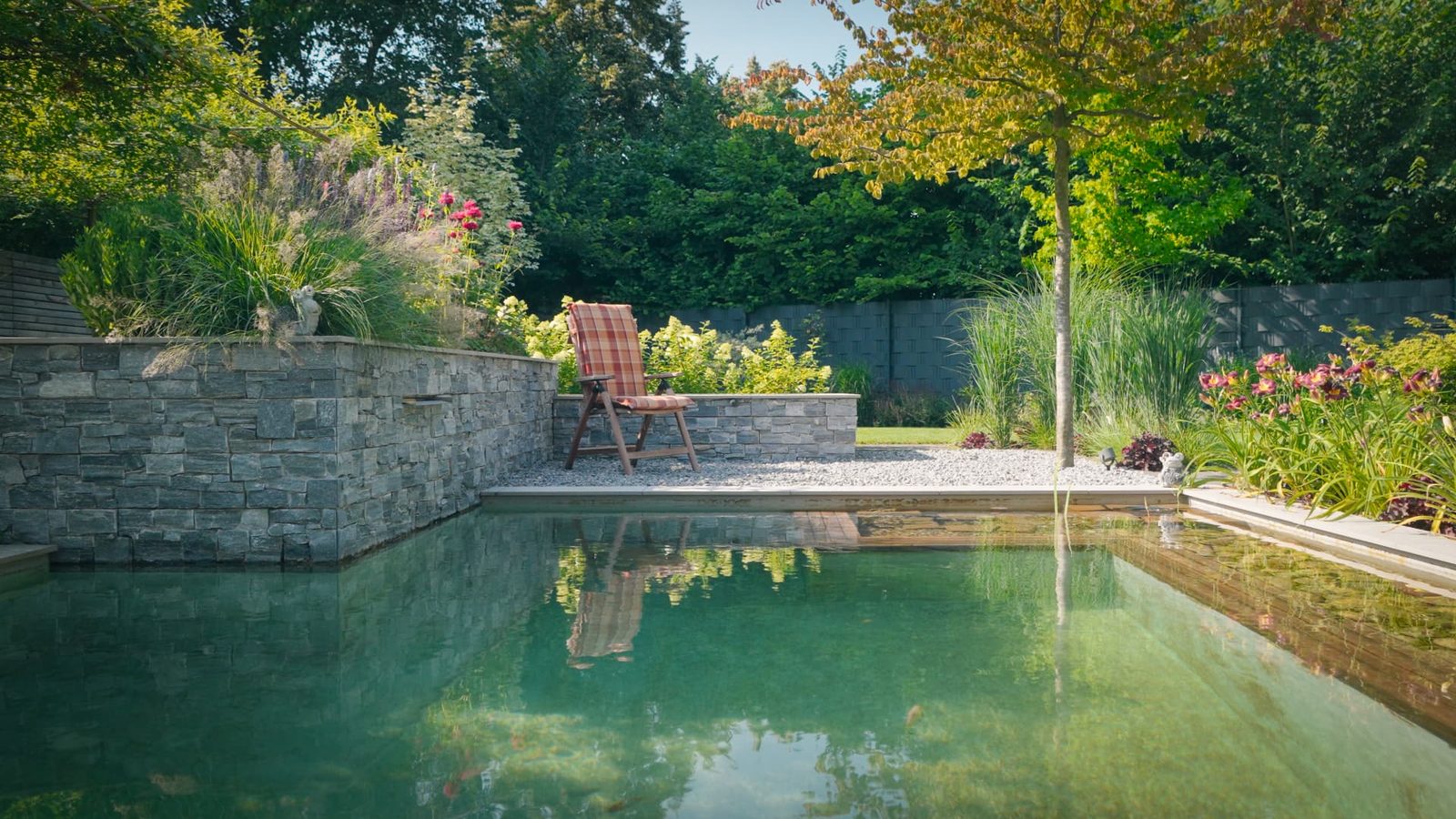 Naturnaher Garten mit Wasserbecken, Natursteinmauer und Stauden